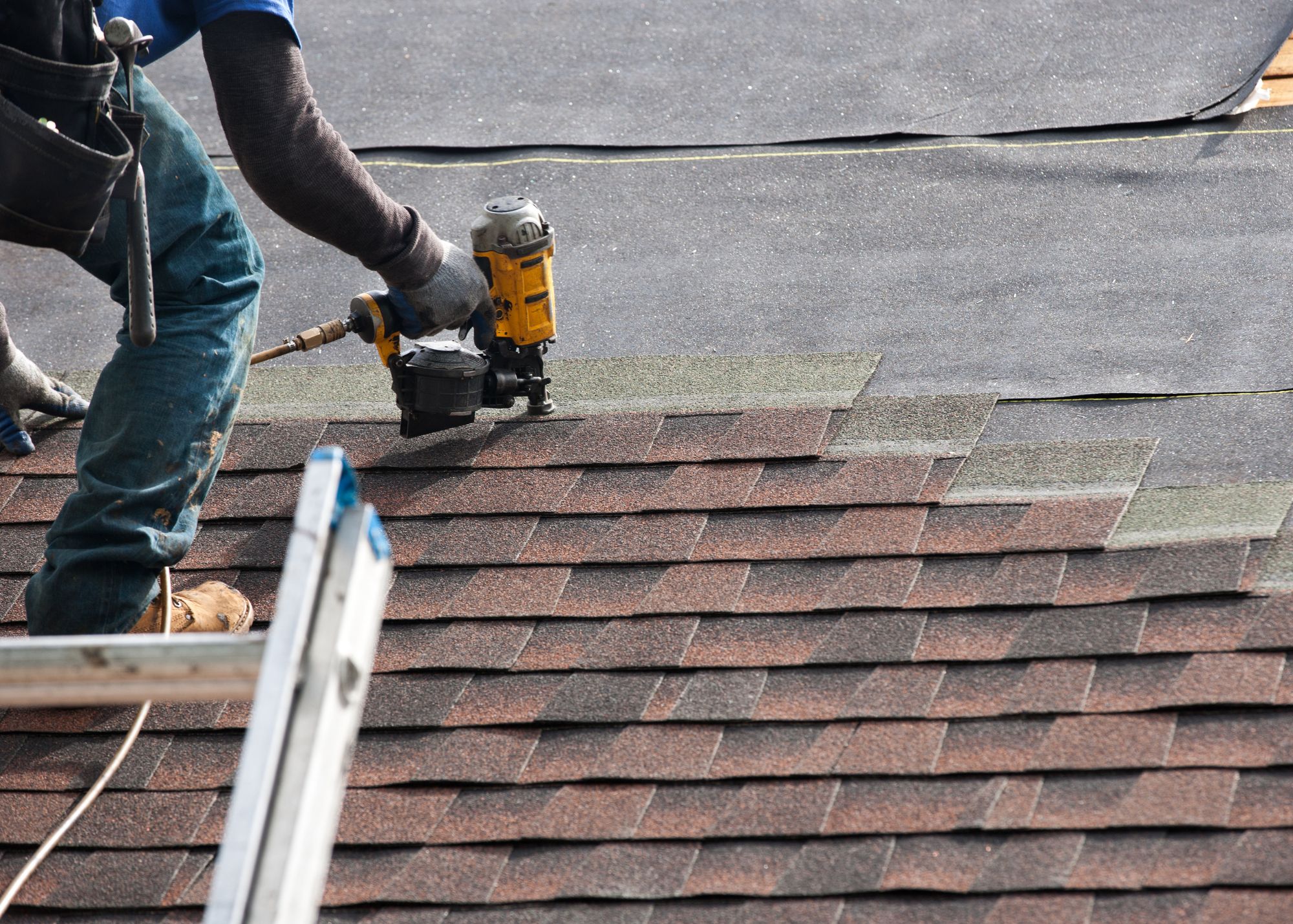 Roofer installing asphalt shingles on a residential roof